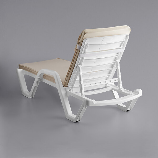 A white chair with a tan cushion.