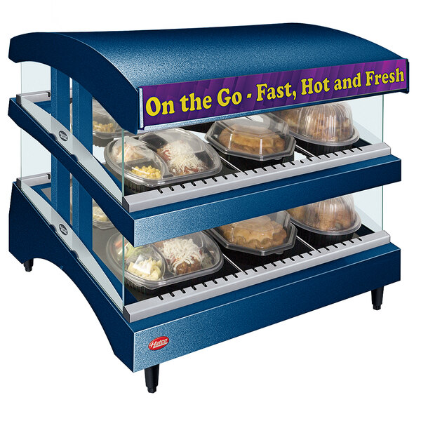 A Hatco Countertop food warmer with shelves holding food on a counter.