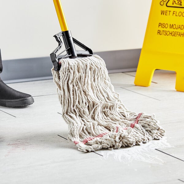 A person using a Choice Natural Cotton Looped End Wet Mop to clean a floor.