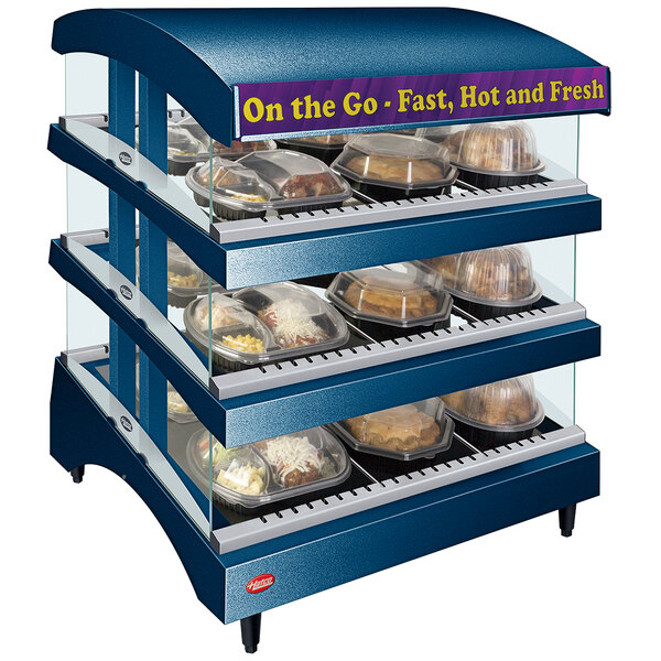 A Hatco countertop food warmer with trays of food on a display case.