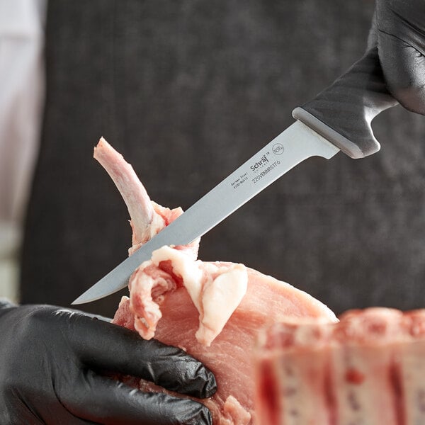 Boning knife separating meat from a bone