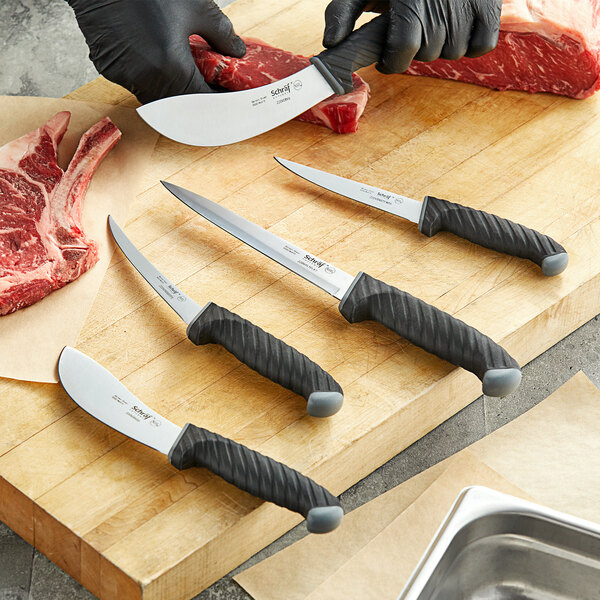 A person using a Schraf Narrow Semi-Flexible Boning Knife with a black TPRgrip handle to cut meat on a cutting board.
