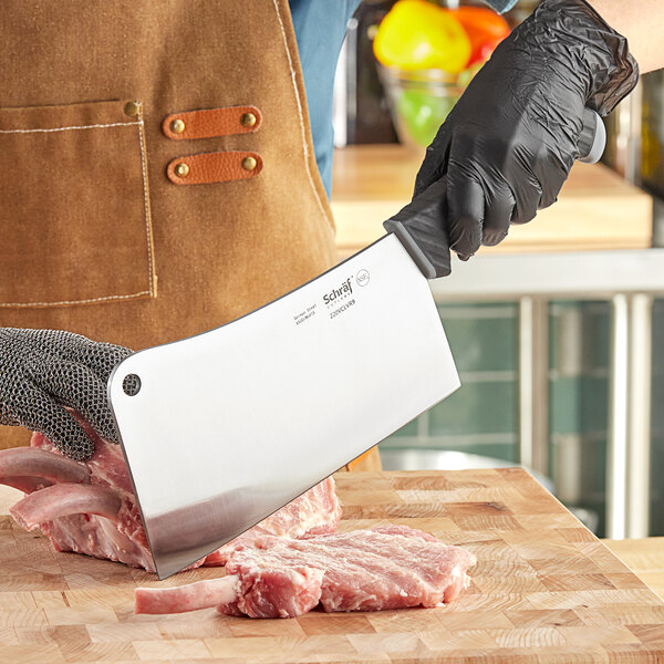 A person cutting meat with a Schraf meat cleaver.