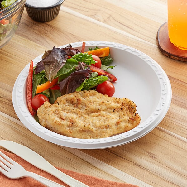 A plate of food with a fork on a yellow surface.