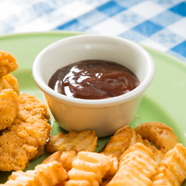 A plate of fried chicken and french fries with a bowl of sauce.