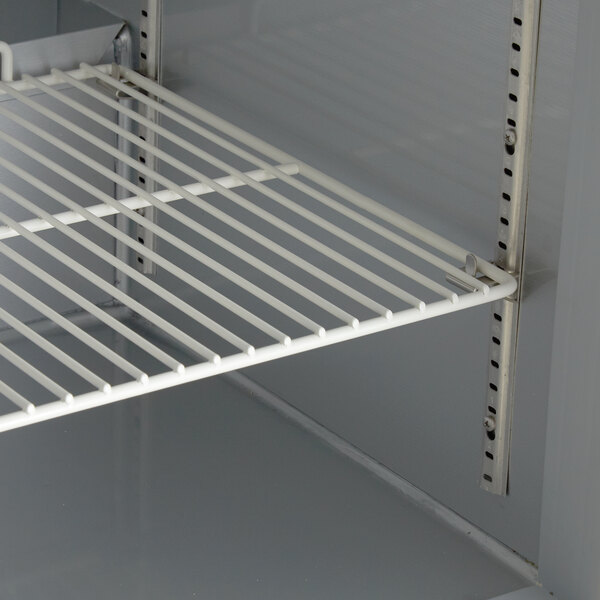 The interior of a Beverage-Air undercounter freezer with a white shelf and metal rack.