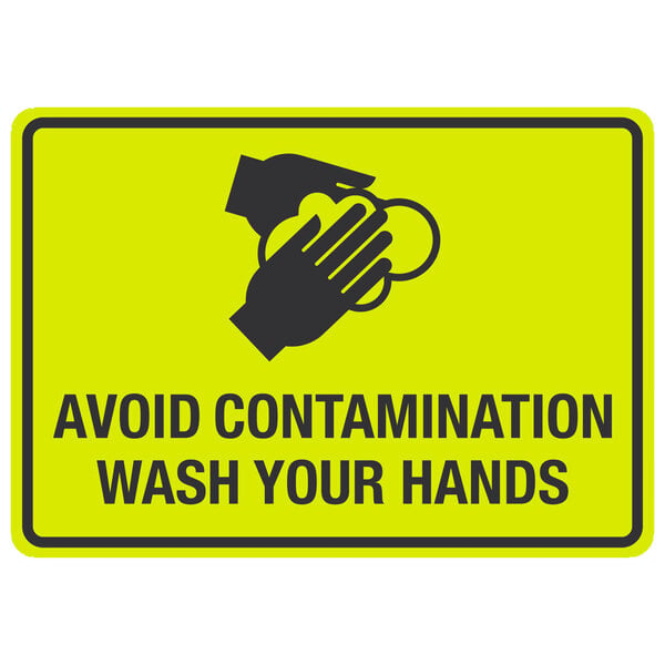 A yellow sign with black text and the words "Avoid Contamination / Wash Your Hands" above a symbol of hands washing.