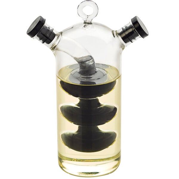 An American Metalcraft glass oil and vinegar cruet with a clear liquid inside.