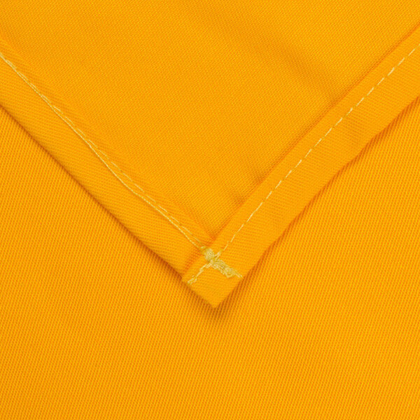 A folded rectangular yellow fabric table cover with a gold hem.