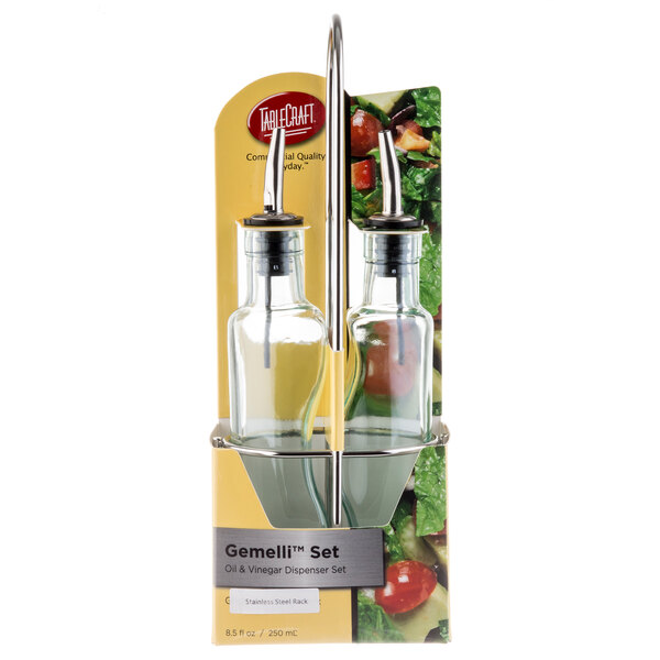 A Tablecraft clear glass oil and vinegar cruet set on a stainless steel rack.