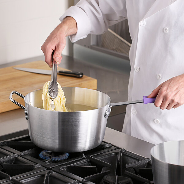 A person using a Choice aluminum sauce pan with a purple handle to cook.