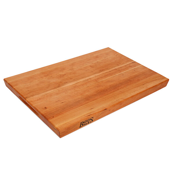 A John Boos cherry wood cutting board with hand grips.