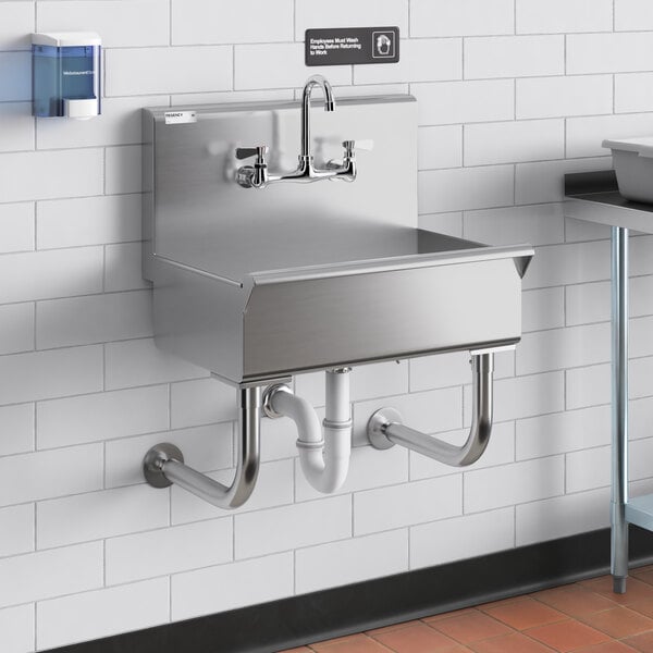 A Regency stainless steel wall-mounted utility sink with faucet.
