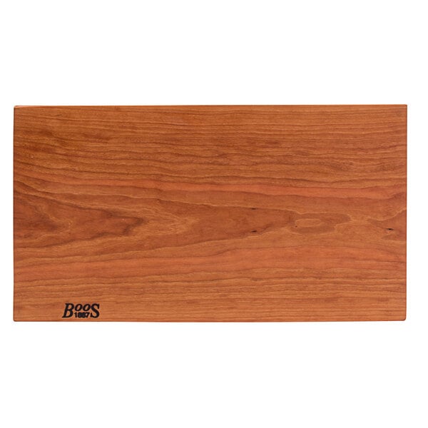 A John Boos cherry wood cutting board with a rustic edge and logo on it.