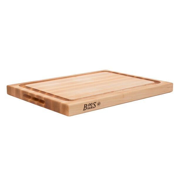 A John Boos maple wood cutting board with hand grips.