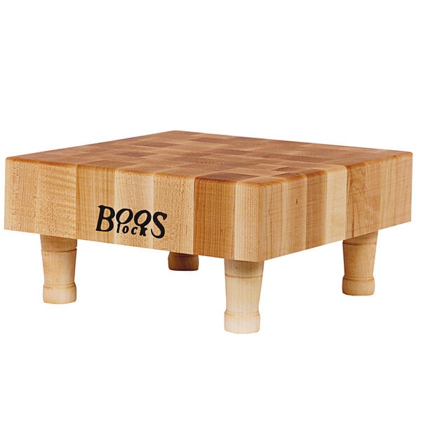 A John Boos maple wood display cutting board with legs.