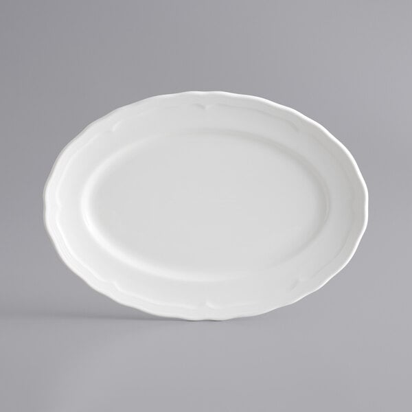 A white Acopa porcelain platter with a scalloped edge.