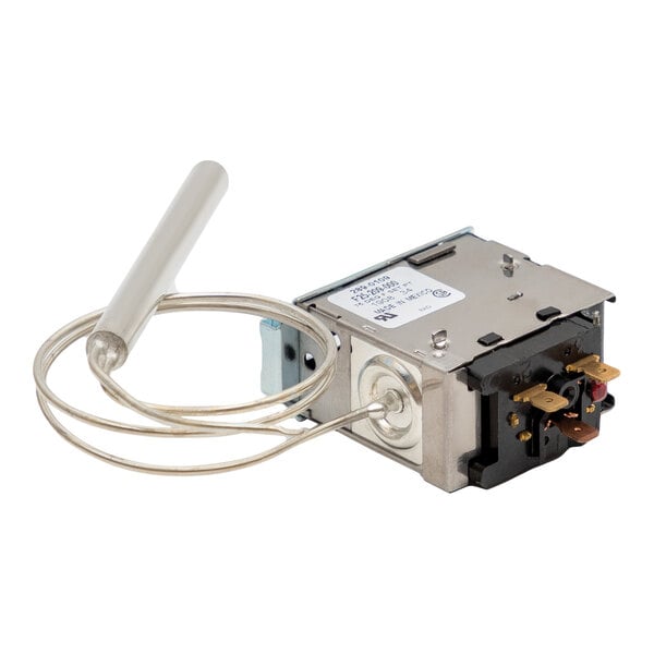 A close-up of a Heatcraft Defrost Term Thermostat, a small metal box with a wire attached.