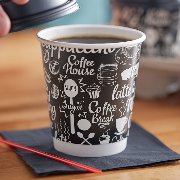 A hand holding a Choice Coffee Break paper hot cup filled with coffee.