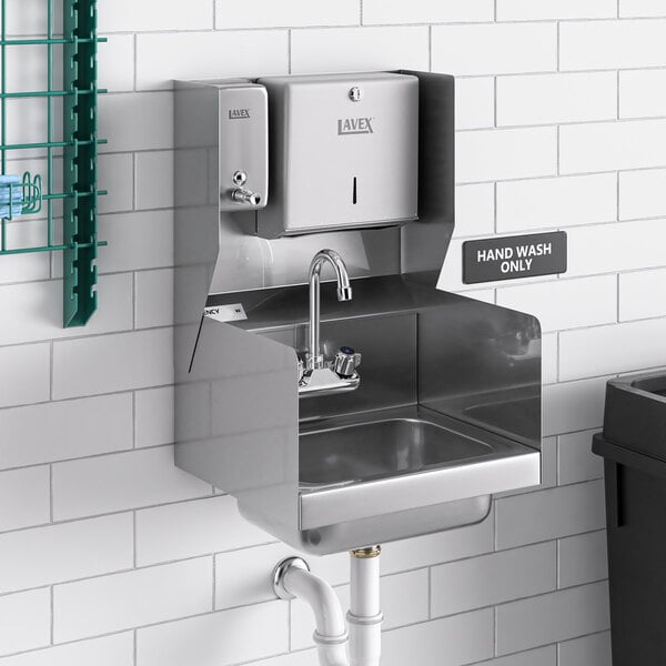 A Regency wall mounted hand sink with side splashes, paper towel, and soap dispenser above it.