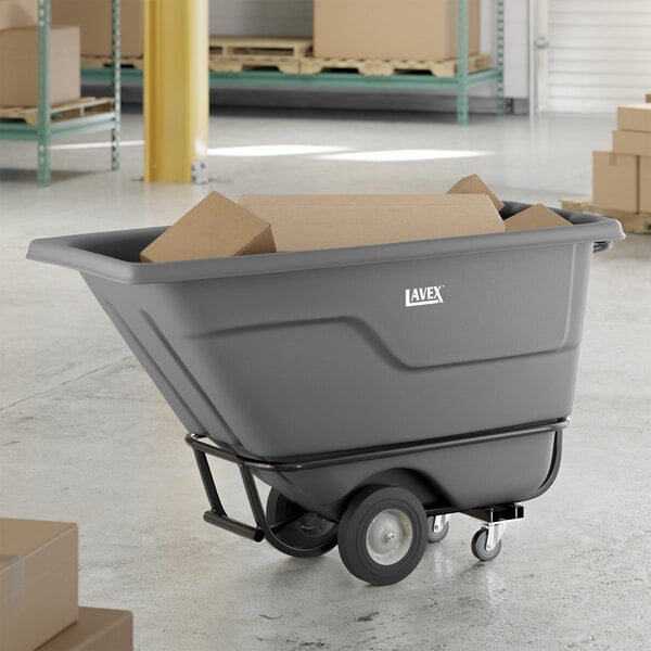 A gray heavy-duty tilt truck or trash cart with an 850 lb. capacity, partially filled with cardboard boxes.