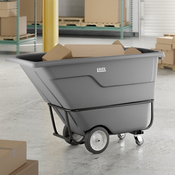 A gray heavy-duty tilt truck or trash cart with a 1 cubic yard capacity, designed for transporting large loads in industrial or commercial settings.