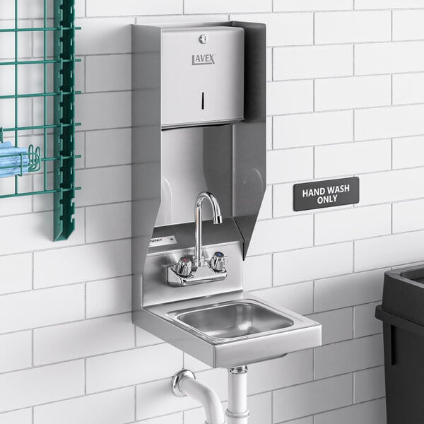 A Regency wall mounted hand sink with a top mounted paper towel dispenser above it.