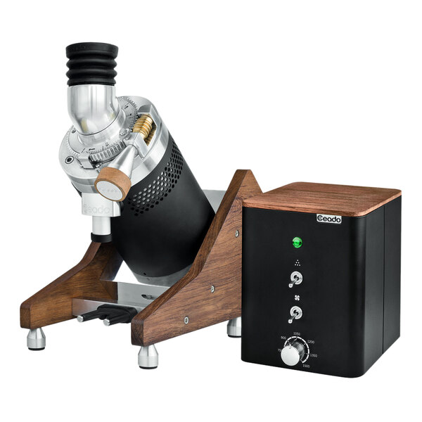 A black and silver Ceado E37Z Hero single dose espresso grinder on a table with a wooden stand.