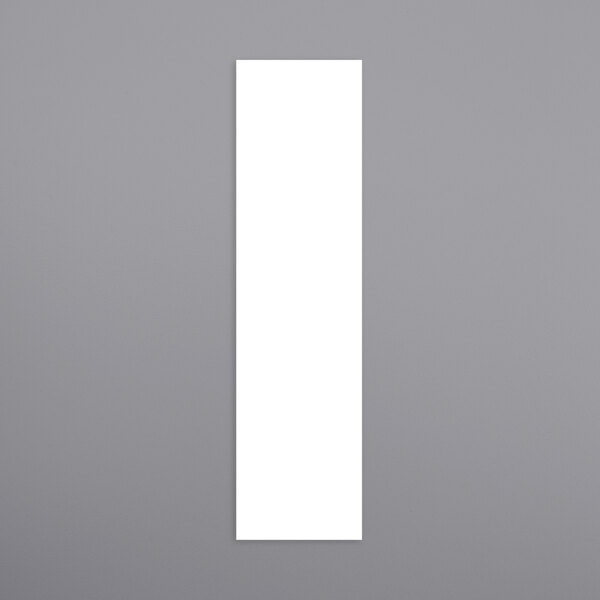 A white rectangular object on a gray surface.