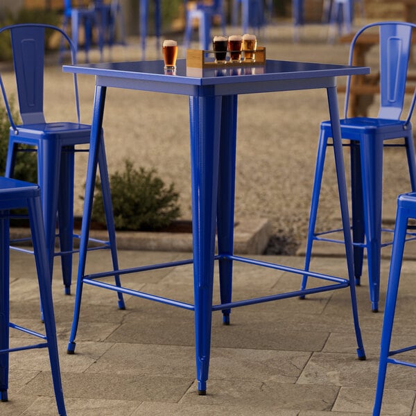 A blue table with a long leg and two blue chairs.