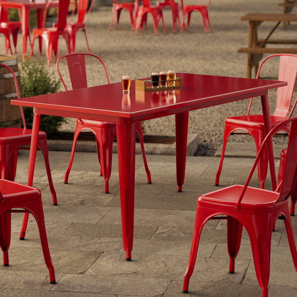 A red table and chairs on a patio.