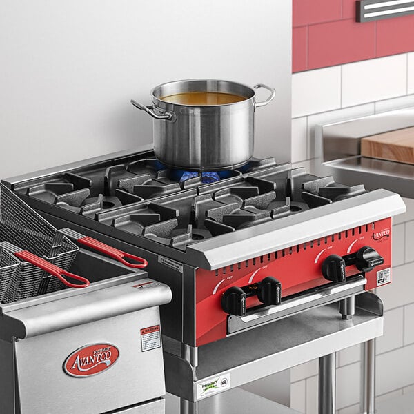 A red Avantco countertop gas range with 4 burners and a pot on top.