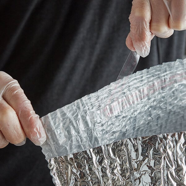 A person in gloves using a Lavex insulated box liner.