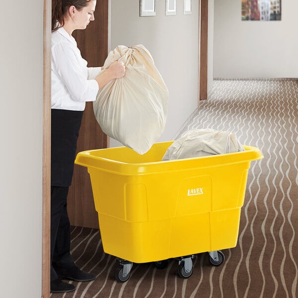 A woman putting a bag into a yellow Lavex cube truck.