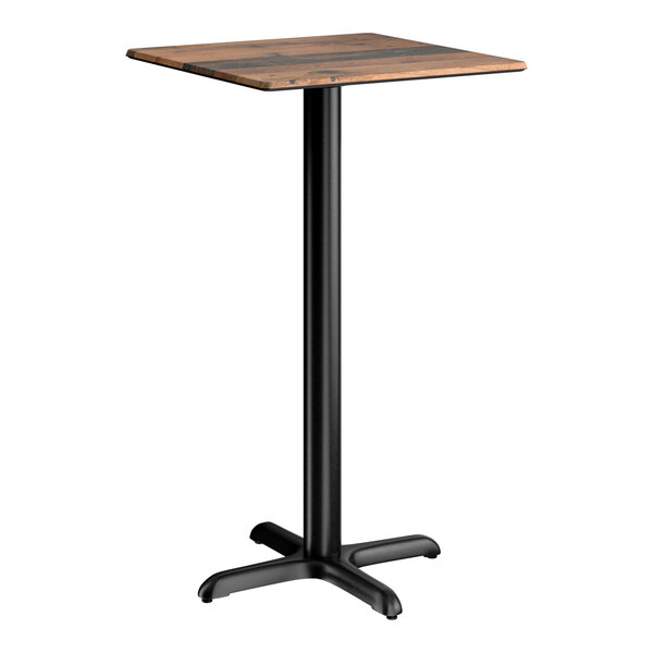 A square bar height table with a textured farmhouse finish and a black cross base plate.