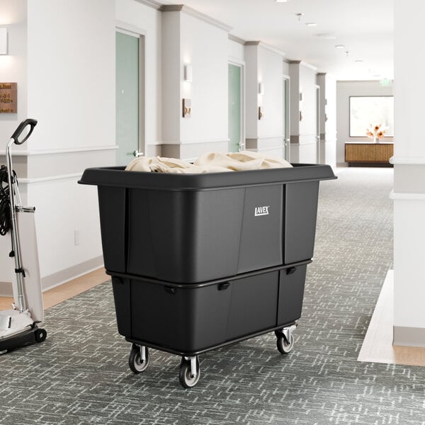 A large black leakproof cube truck with a 16 cubic foot capacity and wheels, used for transporting items such as laundry.