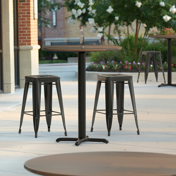 A Lancaster Table and Stools with a Textured Brown Surface on a Patio.