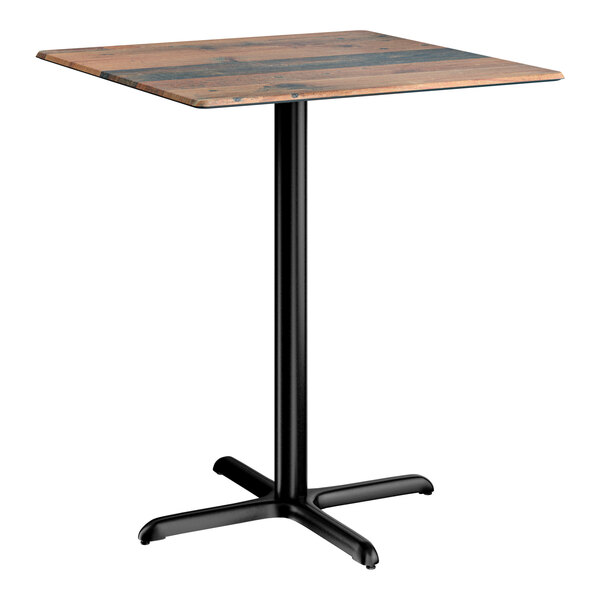 A square bar height table with a textured farmhouse finish top and a black cross base plate.