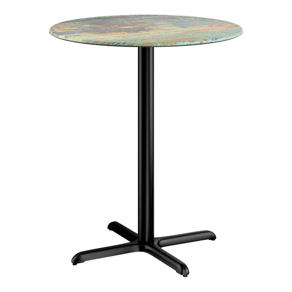 A round bar height table with a textured canyon painted faux metal finish top and a black cross base plate.