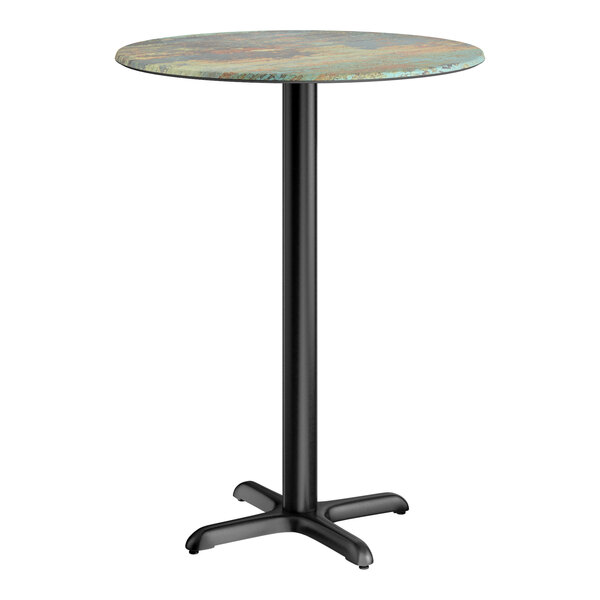 A round bar height table with a textured canyon painted faux metal finish top and a black cross base plate.