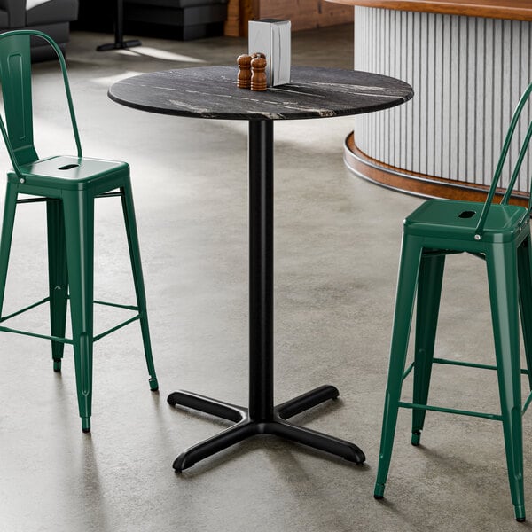 A round bar height table with a smooth dark finish and a black cross base plate.
