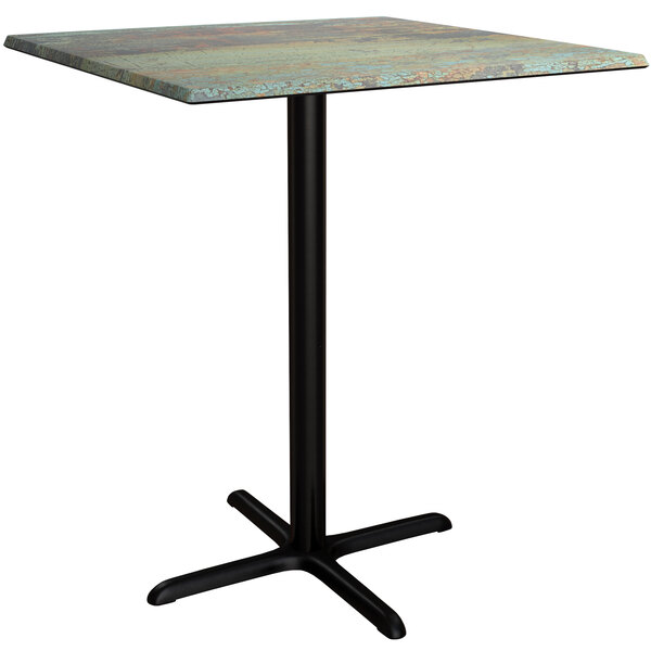 A Lancaster Table & Seating square bar height table with a metal base and a textured canyon top.