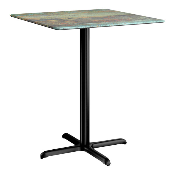 A square bar height table with a textured faux metal finish top and a black cross base plate.