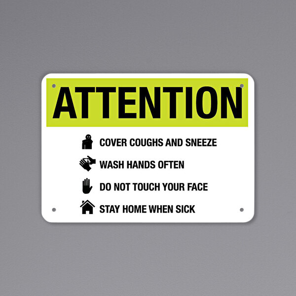 A yellow rectangular sign with black text that says "Attention Cover Coughs And Sneeze" and symbols.