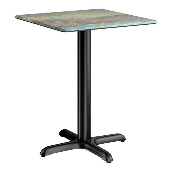 A square standard height table with a textured canyon painted faux metal finish top and a black cross base plate.