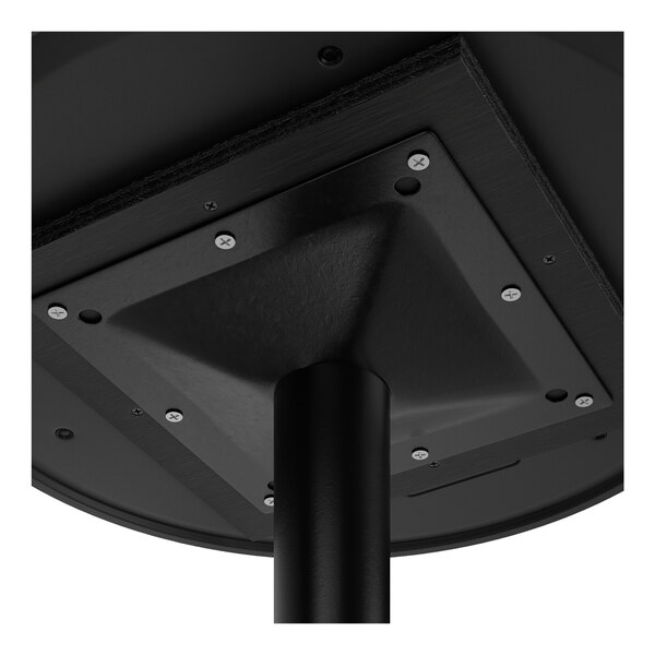 A close-up view of the underside of a round table showing the attachment of a central support column to the tabletop with a metal mounting plate and screws.