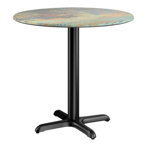 A round standard height table with a textured canyon painted faux metal finish top and a black cross base plate.