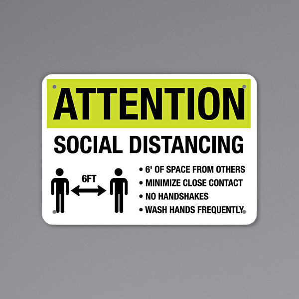 A black and yellow reflective sign with the words "Attention" and "Social Distancing" and a symbol.