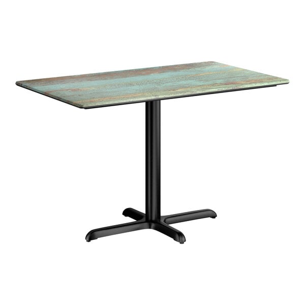 A rectangular standard height table with a textured canyon painted faux metal finish top and a black cross base plate.