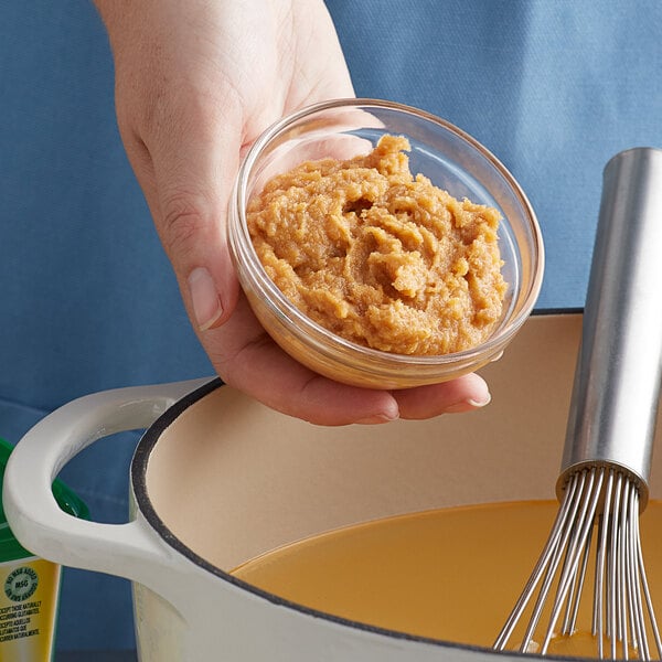 A person holding a bowl of seafood soup made with Knorr Seafood Bouillon Base.